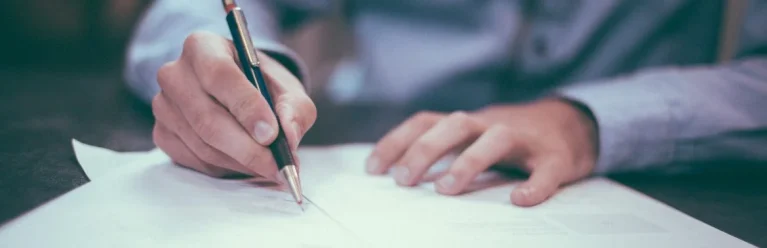 Person, die einen Vertrag unterschreibt
