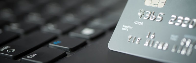 Graue Kreditkarte auf schwarzem Laptop